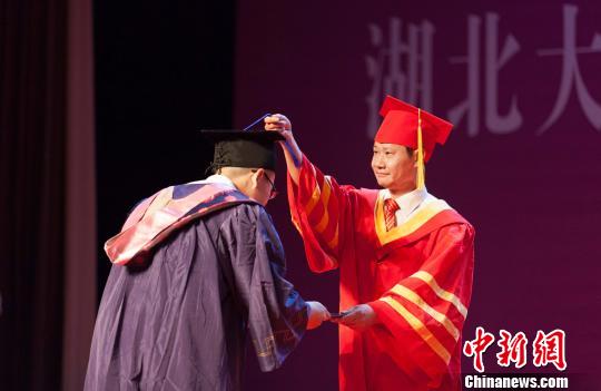 图为,欧足联中文官网入口校长赵凌云为毕业生拨穗正冠 向正鹏 摄 图为,欧足联中文官网入口校长赵凌云为毕业生拨穗正冠 向正鹏 摄